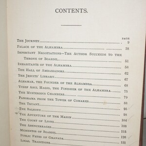 May include: A black and white book with the title "CONTENTS" printed in large, bold letters. The book lists the contents of the book, including the page numbers for each section. The sections include "The Journey", "Palace of the Alhambra", "Important Negotiations", "The Hall of Ambassadors", "The Jesuits' Library", "Alhamar, the Founder of the Alhambra", "Yusef Abul Hagig, the Finisher of the Alhambra", "The Mysterious Chambers", "Panorama from the Tower of Comares", "The Truant", "The Balcony", "The Adventure of the Mason", "The Court of Lions", "The Abencerrages", "Mementos of Boabdil", "Public Fetes of Granada", and "Local Traditions".