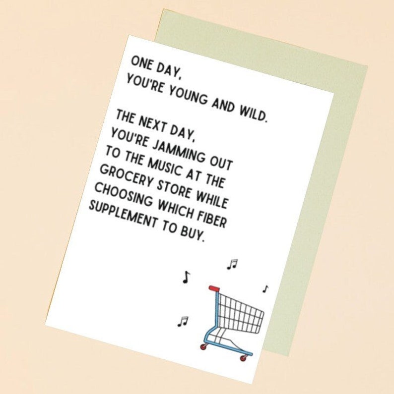 Op de afbeelding: Een witte kaart met zwarte tekst die luidt: "Op een dag ben je jong en wild. De volgende dag jam je mee met de muziek in de supermarkt terwijl je kiest welk vezelsupplement je moet kopen." Onder de tekst staat een cartoon-winkelwagen met muzieknoten.