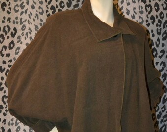 May include: A brown, long-sleeved, oversized sweater with a collar and a single button closure. The sweater is made of a soft, knit fabric.