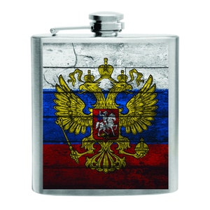Peut inclure: Une flasque en acier inoxydable avec le drapeau russe. Le drapeau est affiché sur un fond en bois avec les armoiries russes en or. La flasque a un bouchon à charnière et est de forme rectangulaire.