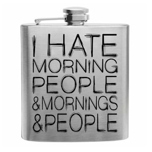 Puede incluir: Una petaca de acero inoxidable con tapa abisagrada. La petaca tiene las palabras "I HATE MORNING PEOPLE & MORNINGS & PEOPLE" impresas en negro en el centro.