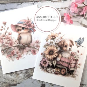 May include: Two greeting cards with watercolor illustrations. One card features a bird wearing a hat perched on a flowering branch. The other card shows a puppy in a wagon surrounded by flowers. The cards are labeled "Assorted Set 8 Different Designs."