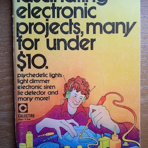 May include: A vintage paperback book titled Fascinating electronic projects, many for under $10. The cover features a colorful illustration of a person wearing green headphones while soldering a blue electronic component surrounded by various tools.