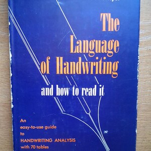 May include: A blue hardcover book titled The Language of Handwriting and how to read it by Oscar N. Myer. The cover features white and orange text with a graphic of a fountain pen nib and lines. It includes an easy-to-use guide to handwriting analysis with 70 tables and 350 handwriting samples.