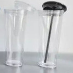 Pu&ograve; includere: Due bicchieri di plastica trasparente con coperchi. Un bicchiere ha un coperchio nero e una cannuccia nera. L'altro bicchiere ha un coperchio trasparente.