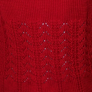 May include: Red knitted sweater with a detailed pattern on the back.