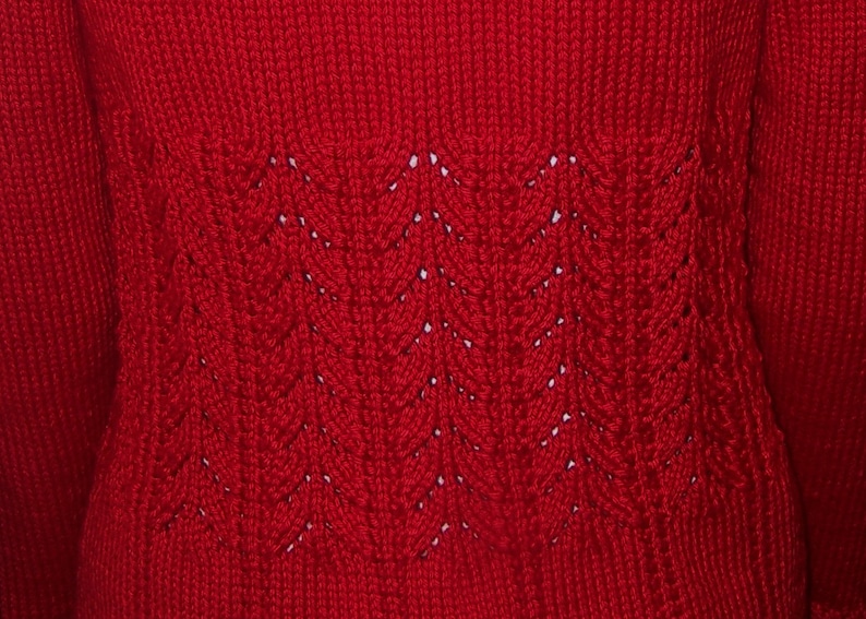 May include: Red knitted sweater with a detailed pattern on the back.