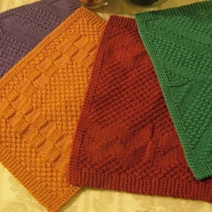 May include: Four knitted dishcloths in different colours and patterns. The dishcloths are purple, orange, red, and green.