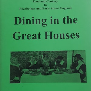 May include: A book cover with a green background and the title "Dining in the Great Houses" in black text. The subtitle is "Food and Cookery in Elizabethan and Early Stuart England". The cover also features a black and white photo of a group of people sitting at a table with food and candles.