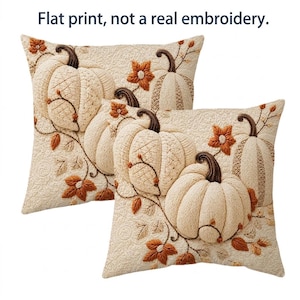 May include: Two square throw pillows featuring a flat print of pumpkins and autumn leaves on a cream background. The design mimics textured embroidery with brown stems and orange accents. The text Flat print, not a real embroidery is visible.