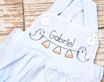 Peut inclure: Salopette bébé bleu clair avec passepoil blanc et broderies de fantômes, de maïs sucré et du nom "Gabriel".