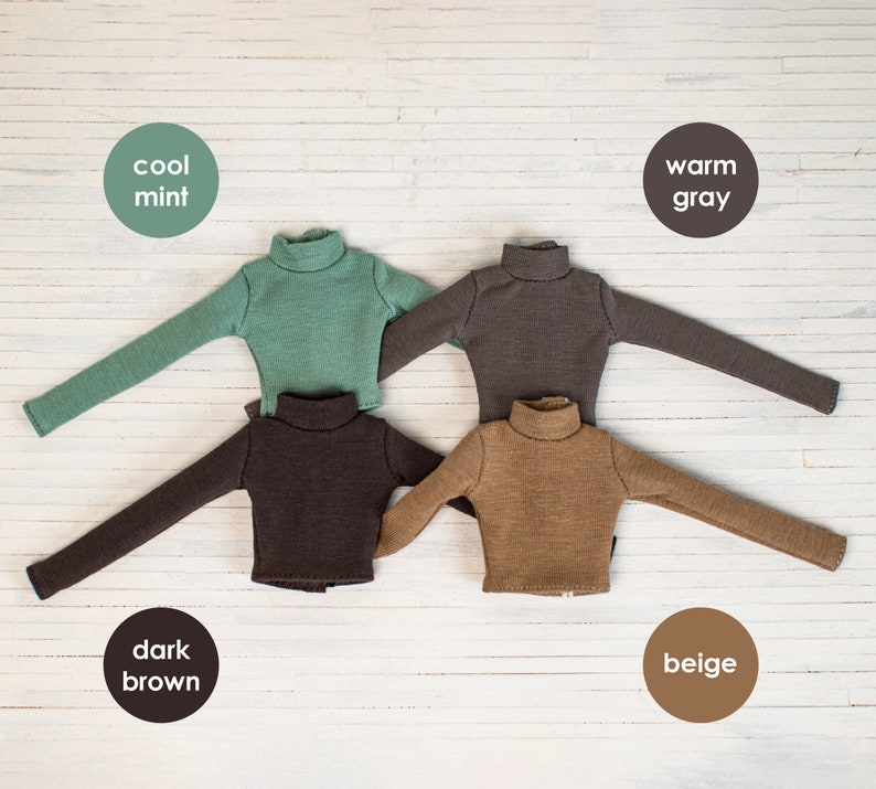 May include: Four long-sleeved turtlenecks in different colors: cool mint, warm gray, dark brown, and beige. The shirts are laid out on a white wooden surface.