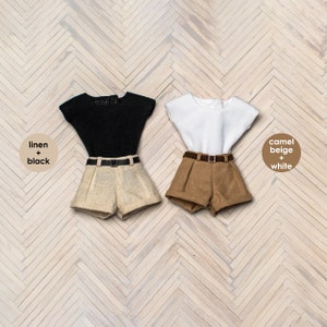 May include: Two pairs of doll-sized shorts and tops. The shorts are linen and camel beige. The tops are black and white.
