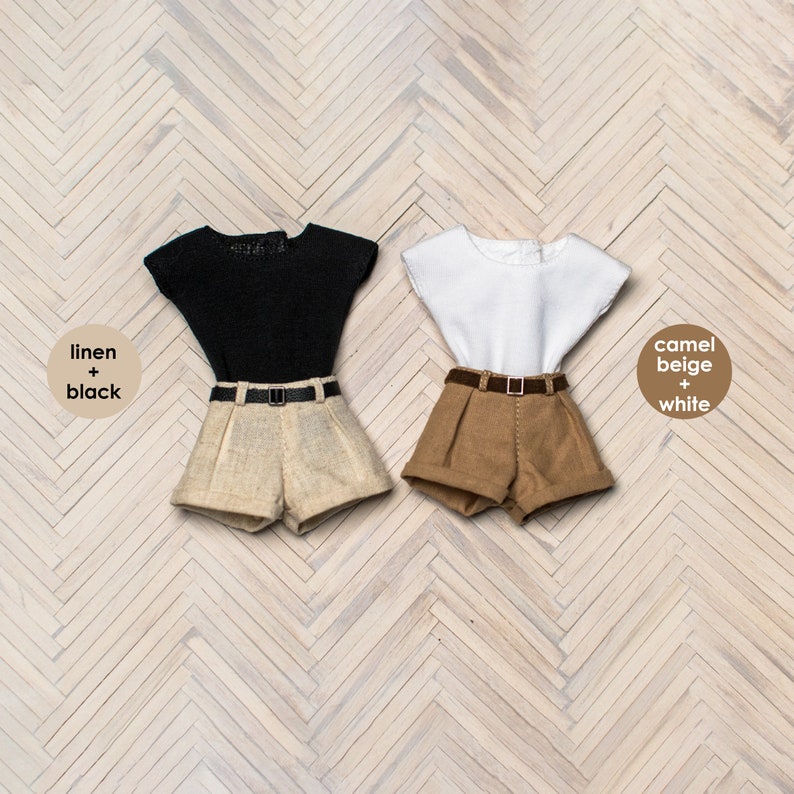 May include: Two pairs of doll-sized shorts and tops. The shorts are linen and camel beige. The tops are black and white.