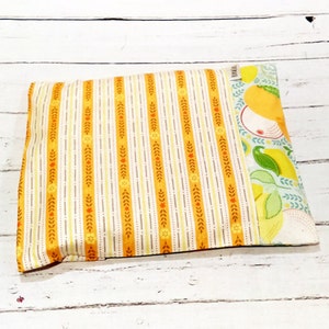 May include: Rectangular cushion with a patterned design. The cushion has a central section with vertical stripes in yellow, orange, and cream. One end features a lemon and leaf pattern on a light blue background.