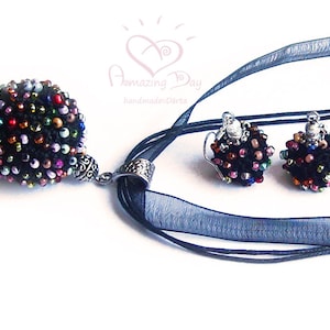 May include: A black beaded necklace and matching earrings with a multi-colored bead design. The necklace has a silver pendant and a black ribbon.