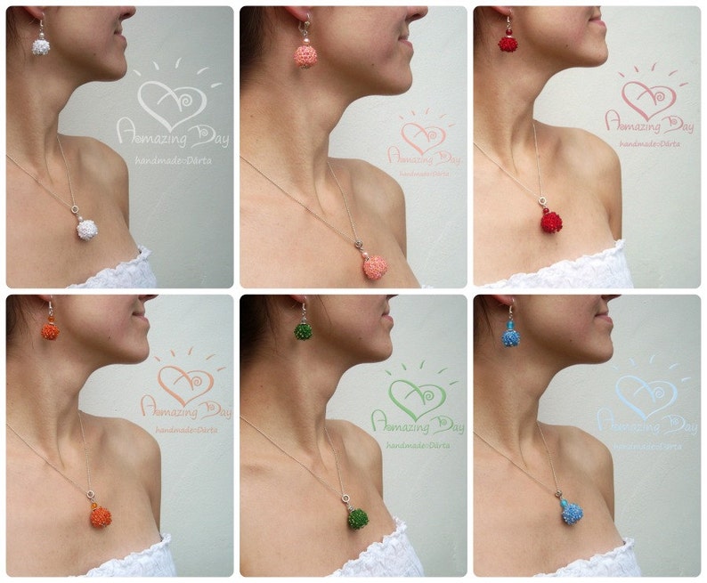May include: Six women wearing white tops and silver necklaces with different colored beaded pendants and matching earrings. The pendants and earrings are all round and have a textured surface. The colors of the pendants and earrings are white, coral, red, green, orange, and blue.