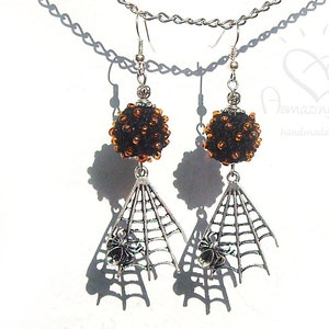 May include: Black and orange beaded dangle earrings with a silver spider web and spider charm.