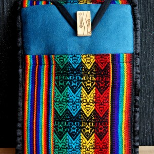 May include: A colourful, striped and patterned phone case with a blue felt lining and a wooden accent piece. The case is made of woven fabric and has a black border.