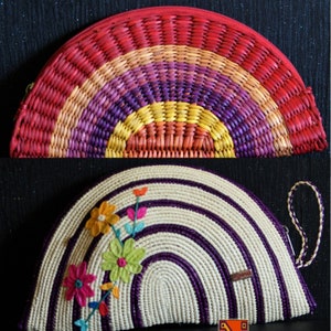May include: Two half-circle woven purses. The top purse is woven with red, orange, yellow, purple, and blue. The bottom purse is woven with white and purple stripes and has a floral design embroidered on the front.
