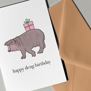 Biglietto di auguri Happy Deng di Eastern Trend Collective. Biglietto di auguri. Moo Deng, cucciolo di ippopotamo pigmeo. Moo Deng. Biglietto di auguri Moo Deng con ippopotamo.