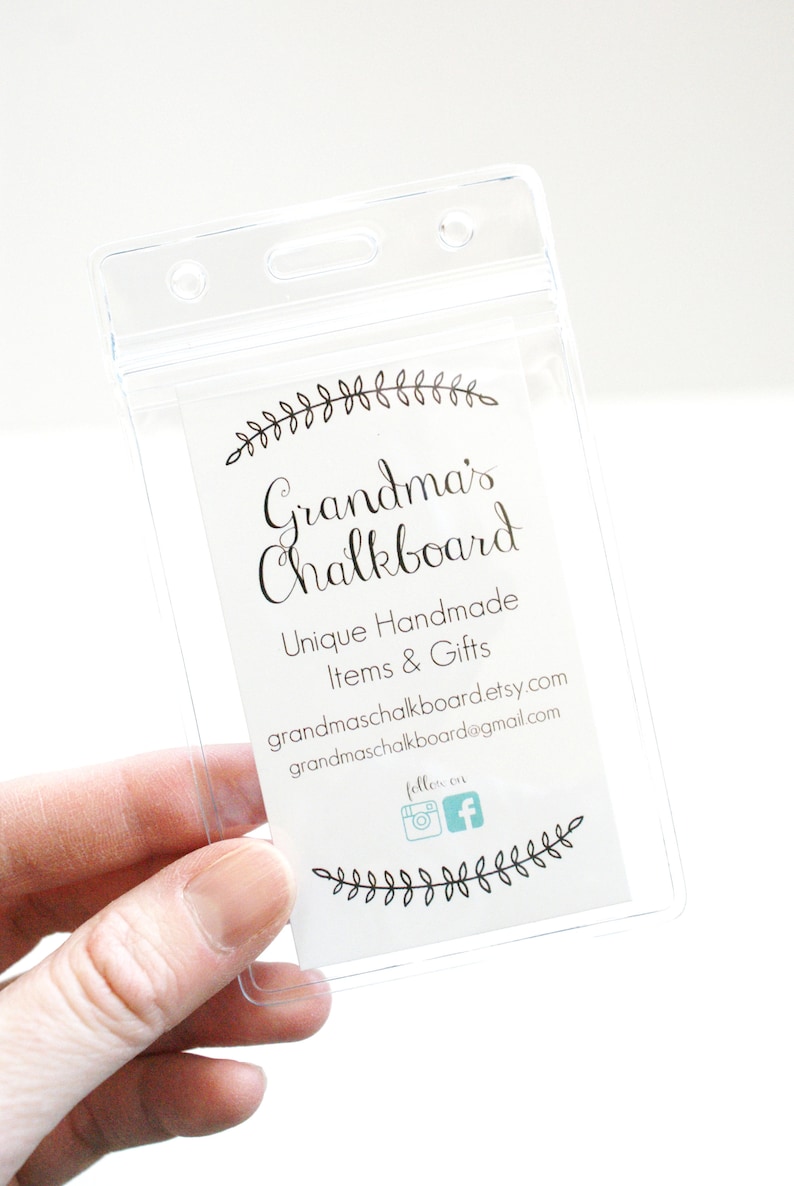 May include: A clear plastic badge holder with a white card inside. The card has black text that reads "Grandma's Chalkboard", "Unique Handmade Items & Gifts", "grandmaschalkboard.etsy.com", "grandmaschalkboard@gmail.com", and "follow on" with Instagram and Facebook icons. The card is decorated with a black floral design.