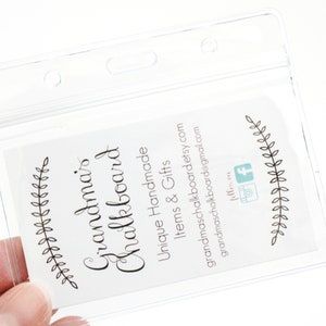 May include: A clear plastic badge holder with a white card inside. The card has black text that reads "Grandma's Chalkboard" and "Unique Handmade Items & Gifts". The card also has a website address, "grandmaschalkboard.etsy.com", and an email address, "grandmaschalkboard@gmail.com".