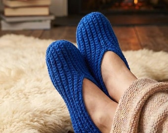 May include: A pair of vibrant royal blue slippers crafted with a textured, ribbed crochet knit pattern. The slippers feature a rounded toe design and a low-cut opening, providing a snug fit around the foot with a consistent, uniform stitch.