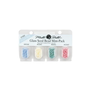 May include: A pack of four small containers of glass seed beads. The beads are in the colors blue, white, green, and pink. The pack is labeled "Mile Hill Glass Seed Bead Mini-Pack".
