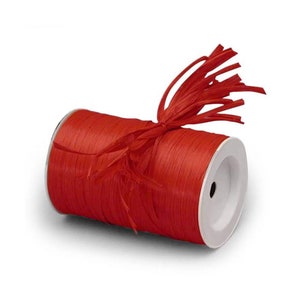 May include: A spool of red raffia ribbon with a bow tied around it. The ribbon is made of natural fibers and has a rustic look.