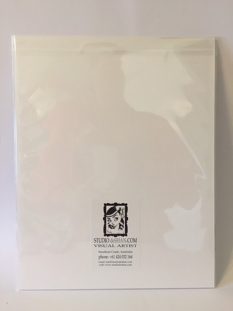 May include: A white card with a black and white illustration of a girl with a flower in her hair. The card has text that reads "STUDIO deSHAN.COM VISUAL ARTIST Sunshine Coast, Australia phone: +61 424 032 164 email: info@studiodeshan.com www: www.studiodeshan.com"