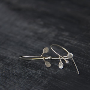 以下が含まれることがあります： 小さな丸い葉が付いた繊細な枝のデザインのシルバーイヤリング