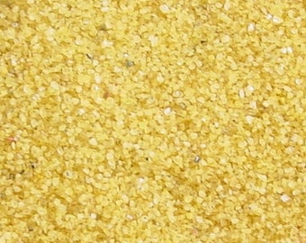 May include: Close-up of fine yellow couscous, a type of pasta made from semolina.