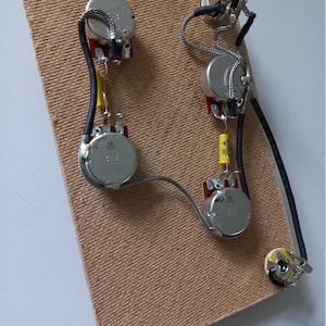 Professional ES335-style hollow body wiring loom with optional Varitone. Split shaft, course spline, 18 knurles, metric.