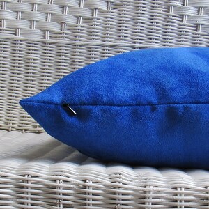 Op de afbeelding: Een koninklijk blauw kussen met een rits. Het kussen is gemaakt van een zachte, fluweelachtige stof.