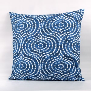 May include: Blue and white patterned throw pillow with a geometric design of circles and dots.