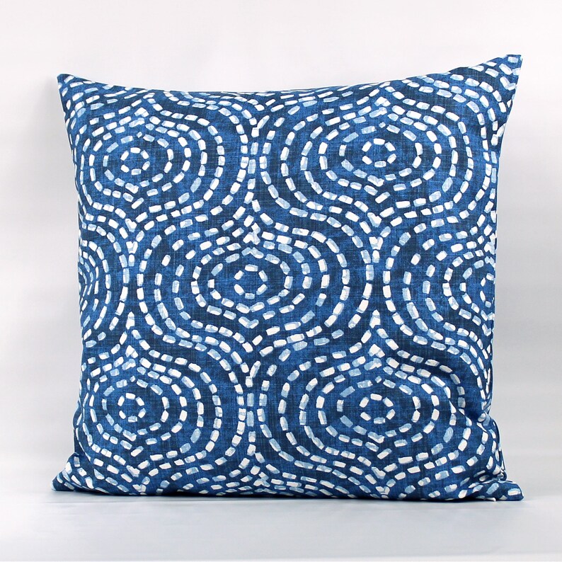 May include: Blue and white patterned throw pillow with a geometric design of circles and dots.