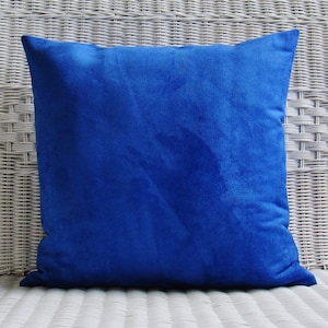 Op de afbeelding: Een helderblauw vierkant kussen met een zachte, fluweelzachte textuur.