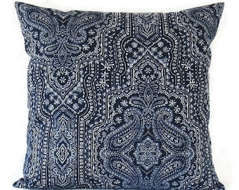 Puede incluir: Una almohada cuadrada con un patrón paisley azul marino y blanco. La almohada tiene un fondo blanco con un diseño paisley azul marino.