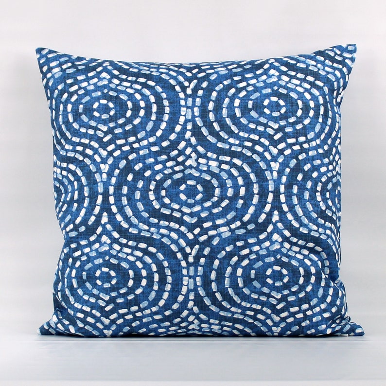 May include: Blue and white patterned throw pillow with a geometric design of circles and dots.