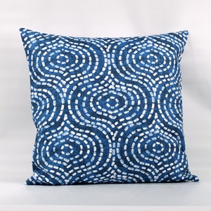 May include: Blue and white throw pillow with a geometric pattern of circles and dots.