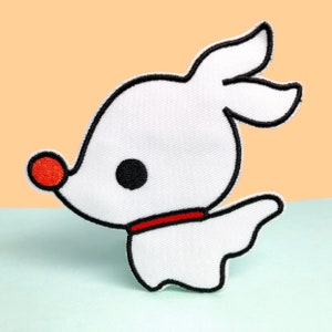 May include: White embroidered patch of a cartoon ghost dog with a red nose and collar, black eye, and black outline. Set against a light orange and blue backdrop.