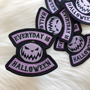 May include: Purple and black embroidered iron-on patch with a grinning pumpkin and the text "Everyday is Halloween".