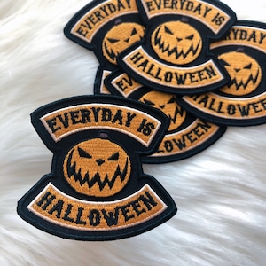 May include: Black and white embroidered patch with a yellow pumpkin face and the text "EVERYDAY IS HALLOWEEN".