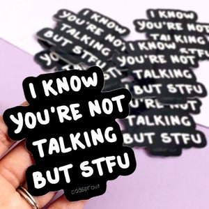 May include: Black and white sticker with the text "I know you're not talking but stfu".
