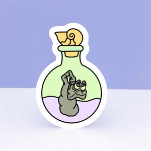 May include: A sticker of a green glass bottle with a purple liquid and a gray creature inside. The bottle has a yellow seashell stopper.