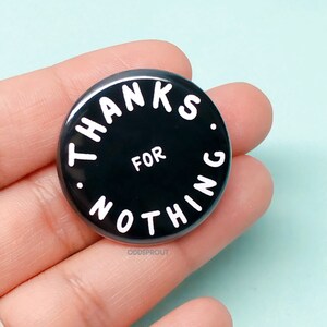 May include: Black button with white text that reads "THANKS FOR NOTHING."