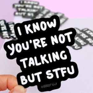 May include: Black and white sticker with the text "I know you're not talking but stfu" in a bold, rounded font. The sticker is on a pink background.