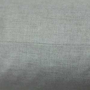 a close-up view of a grey fabric, possibly a piece of clothing or a textile.
