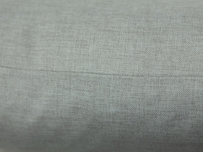 a close-up view of a grey fabric, possibly a piece of clothing or a textile.